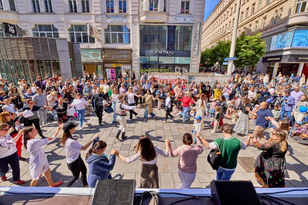 Viele Menschen tanzen auf der Straße in einem Kreis